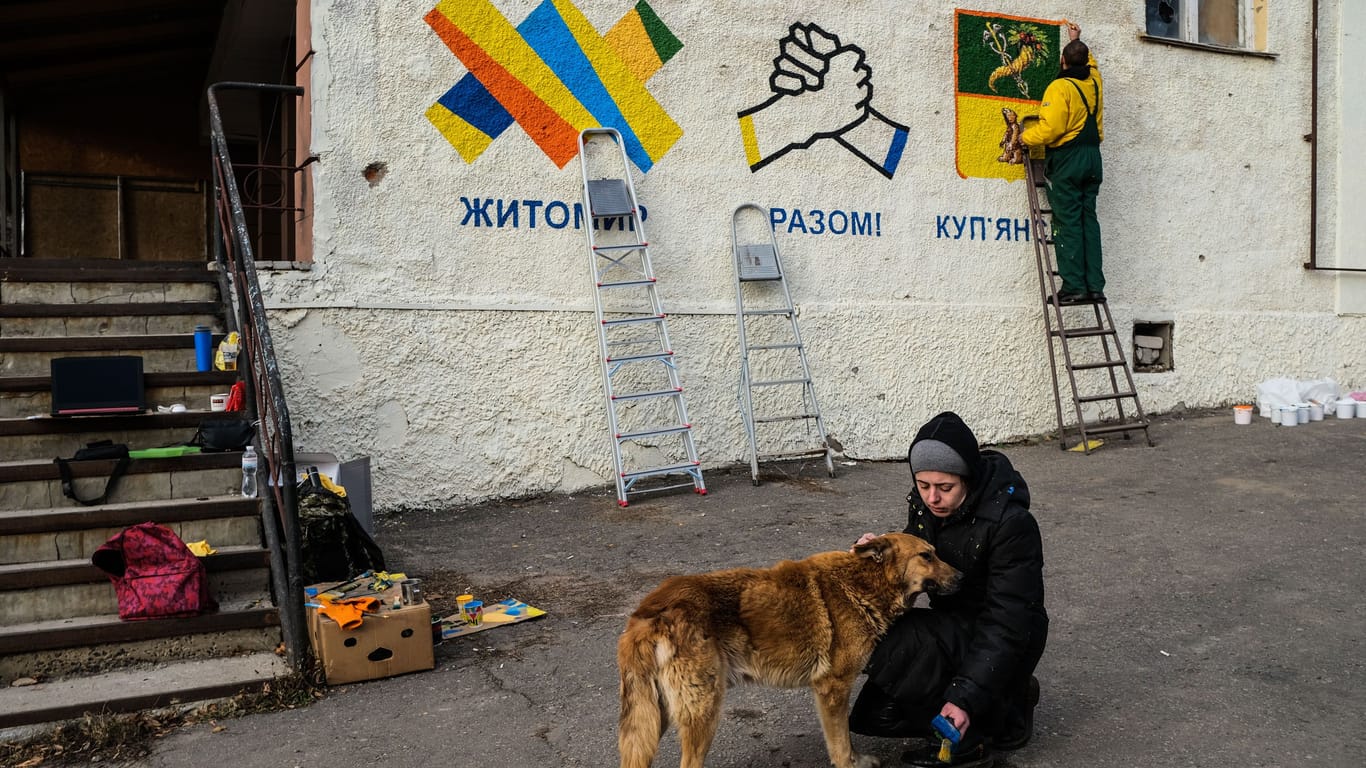 Das Leben kommt langsam zurück nach Kupjansk: Künstler bemalen die Fassade des Rathauses.