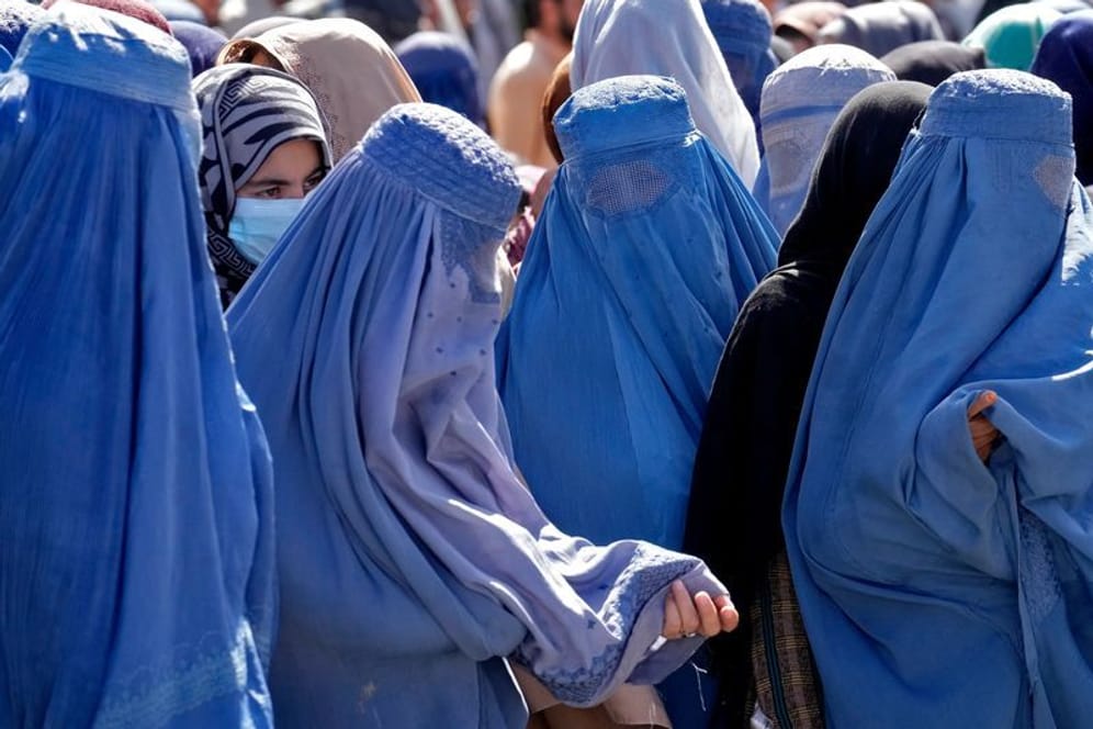 Frauen in Burkas warten im Sommer in Kabul auf Lebensmittelrationen: Das Bildungsverbot für Frauen trifft alle privaten und öffentlichen Universitäten und Hochschulen.