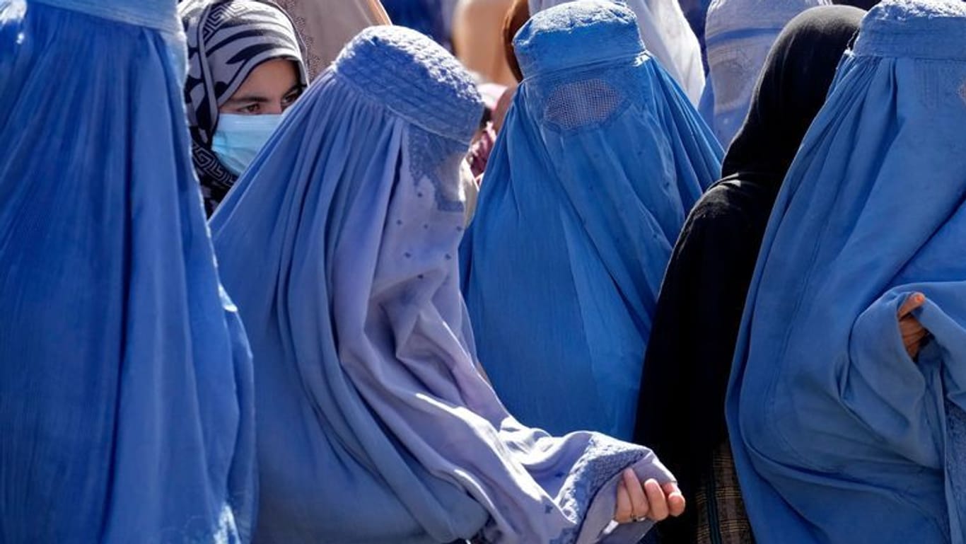Frauen in Burkas warten im Sommer in Kabul auf Lebensmittelrationen: Das Bildungsverbot für Frauen trifft alle privaten und öffentlichen Universitäten und Hochschulen.
