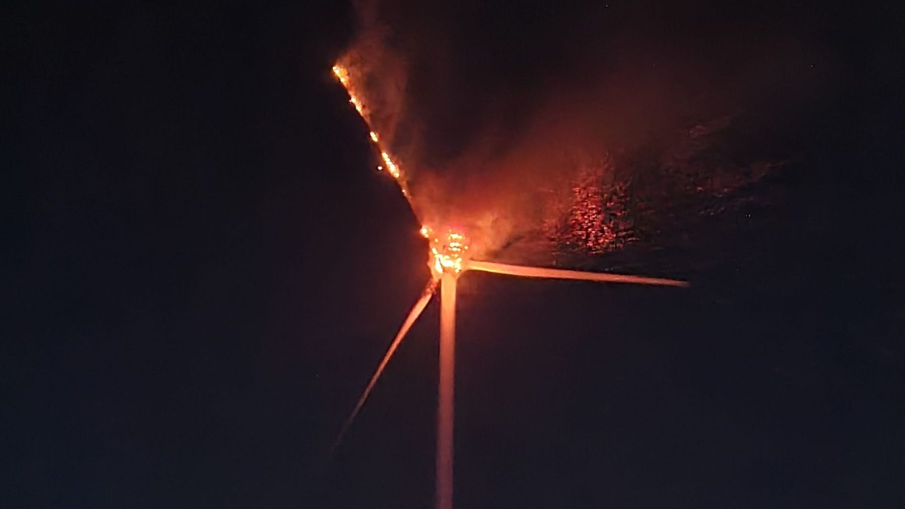 Ein Windrad brennt: Die Feuerwehr warnt vor herabstürzenden Trümmerteilen.