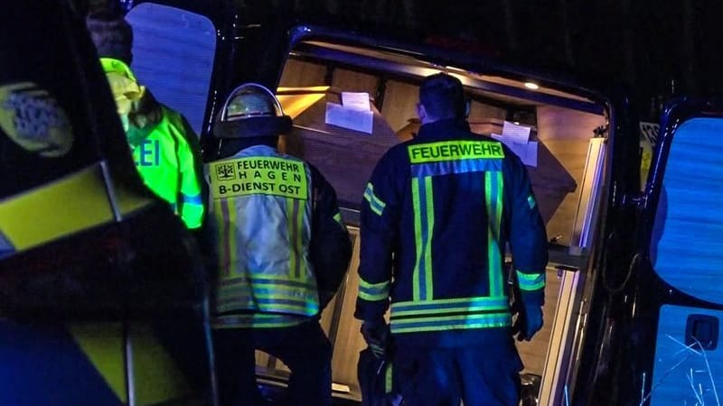 Einsatzkräfte stehen vor dem verunglückten Leichenwagen: Die Särge blieben unbeschädigt.