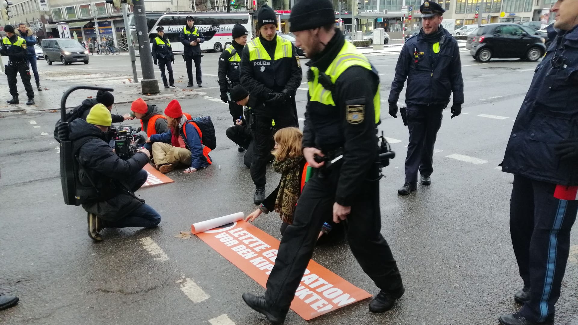 Drei Klimaaktivisten kleben auf der Straße am Stachus in München: Sie blockierten die Straße, obwohl auch die Polizei davon vorab wusste. Drei Klimaaktivisten kleben auf der Straße am Stachus in München: Sie blockierten die Straße, obwohl auch die Polizei davon vorab wusste.