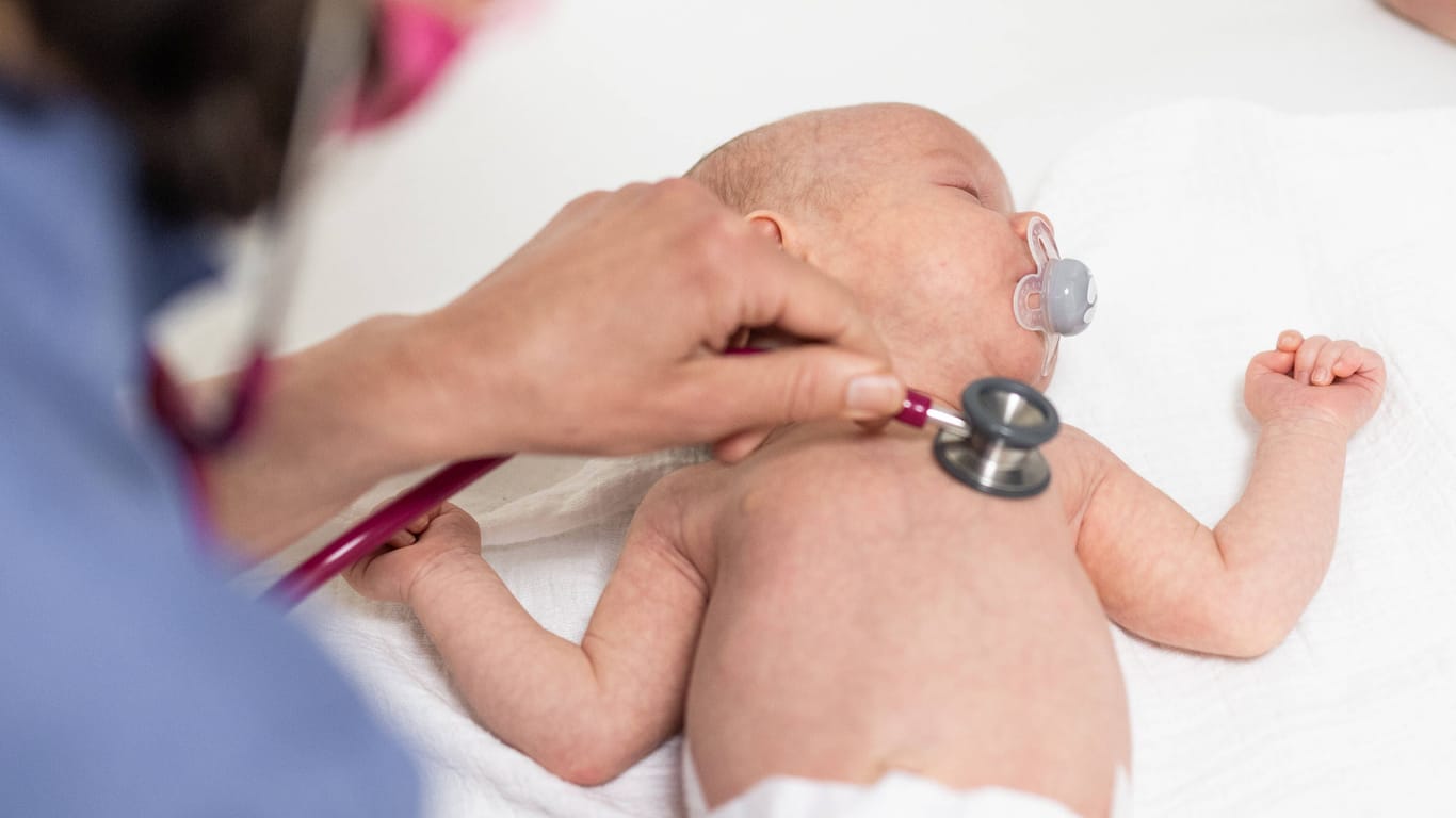 Ein Säugling wird untersucht (Archivbild): Die Lage in den Kinderkliniken in Berlin bleibt angespannt.