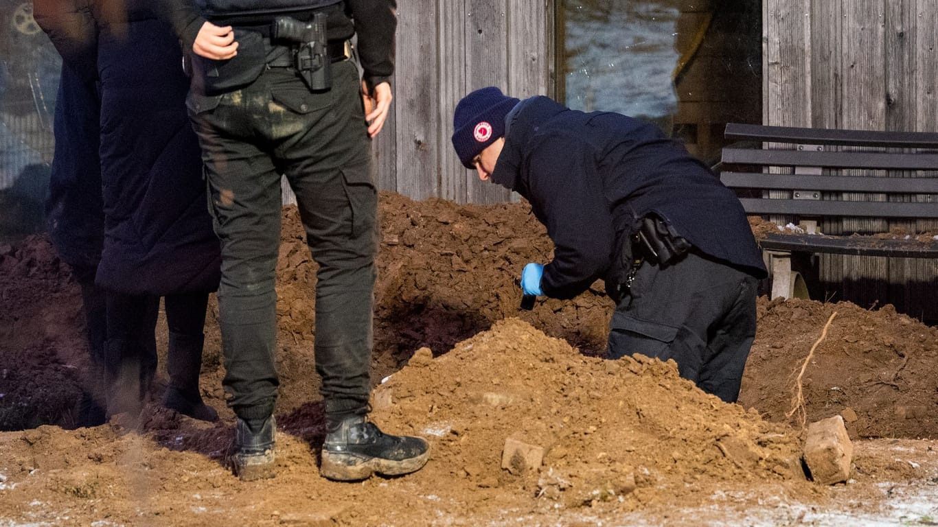 Ermittler der Polizei arbeiten an einem Erdloch in einem Garten eines Mehrfamilienhauses in Alt-Mölln: Hier wurde der in Textilien eingewickelte Leichnam gefunden.