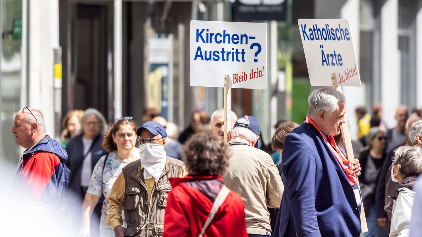 Am Rande des 102. Deutschen Katholikentags in Stuttgart: Zwei Männer wollen Kirchenmitglieder zur Abkehr von einem möglichen Austritt überzeugen.