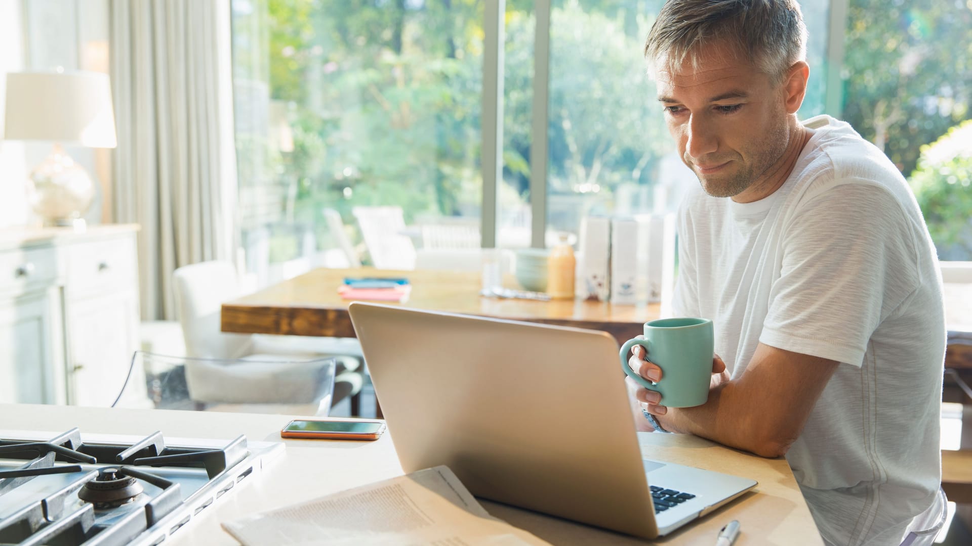 Mann mit Kaffee am Laptop