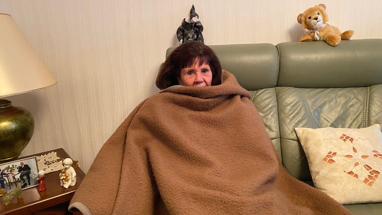 Karin Dierke frierend auf ihrem Sofa: Die Rentnerin leidet unter der Situation.