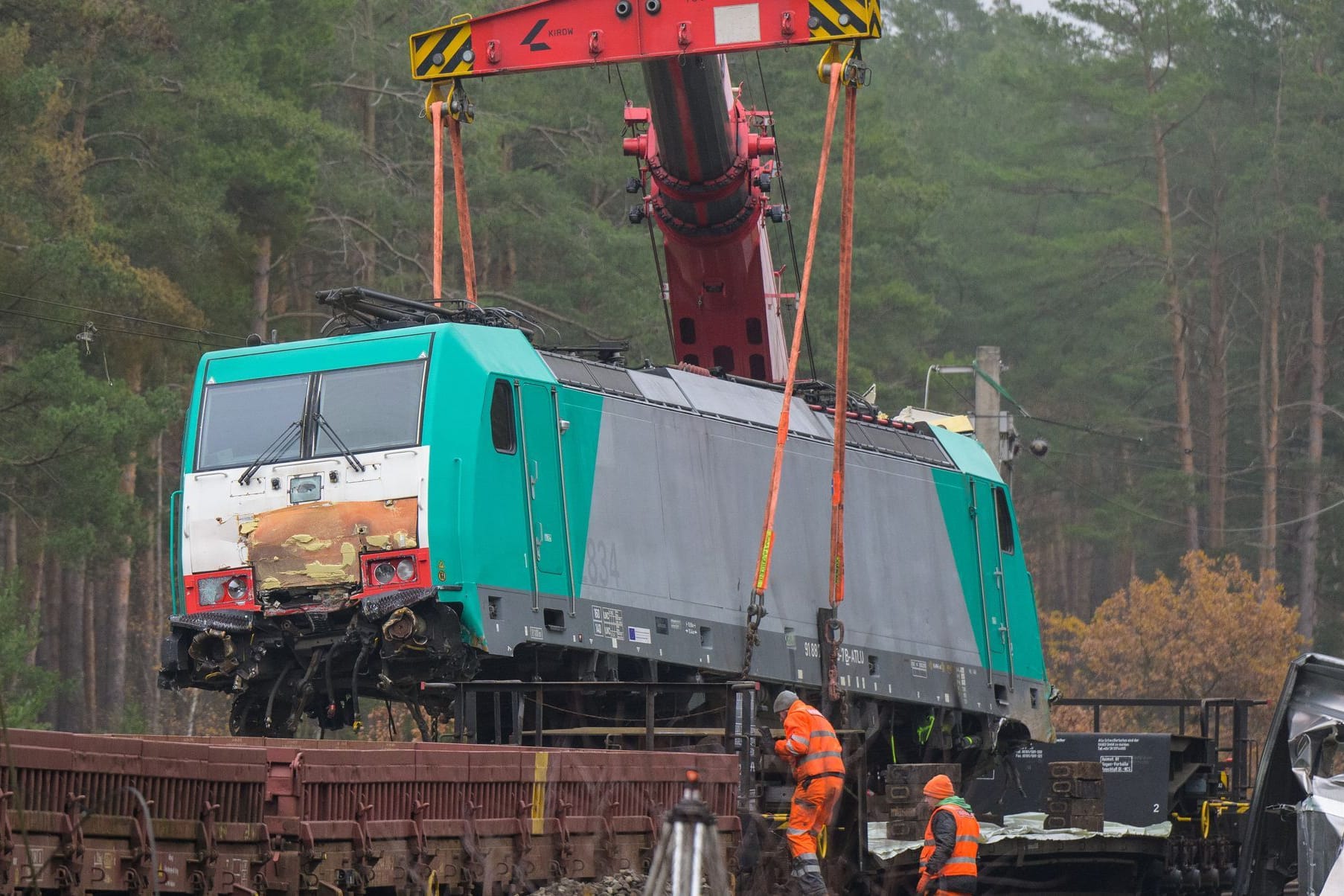 Die verunfallte Lok wird mit einem Kran auf einen Waggon gehoben. Nach einem Zugunfall auf der Bahnstrecke zwischen Hannover und Berlin gehen die Aufräumarbeiten weiter.