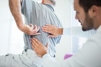 Mann mit Rückenschmerzen beim Arzt