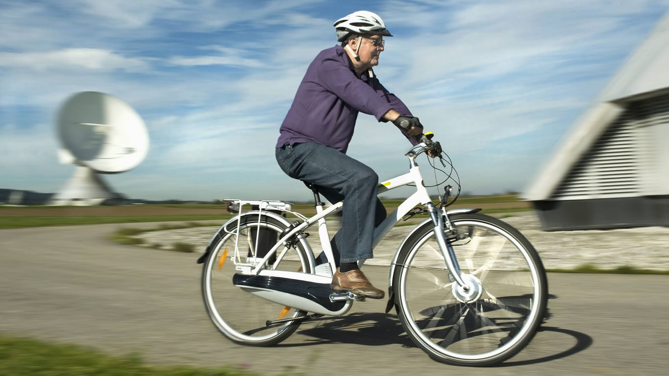 Ein älterer Mann fährt auf einem E-Bike.