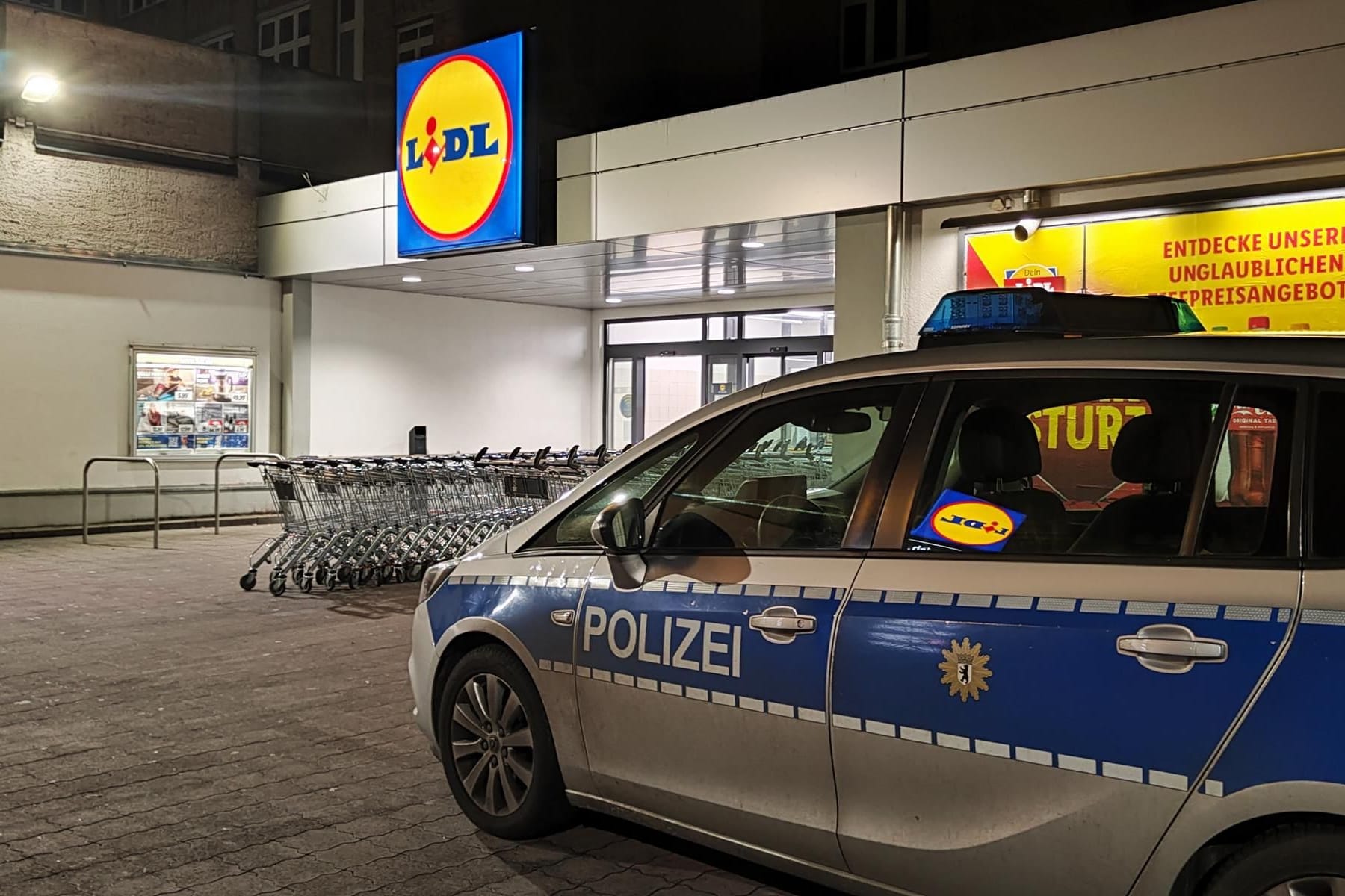 Ein Streifenwagen vor einer Lidl-Filiale in Neukölln: Offenbar wurde ein kompletter Rollwagen mit Feuerwerk gestohlen.