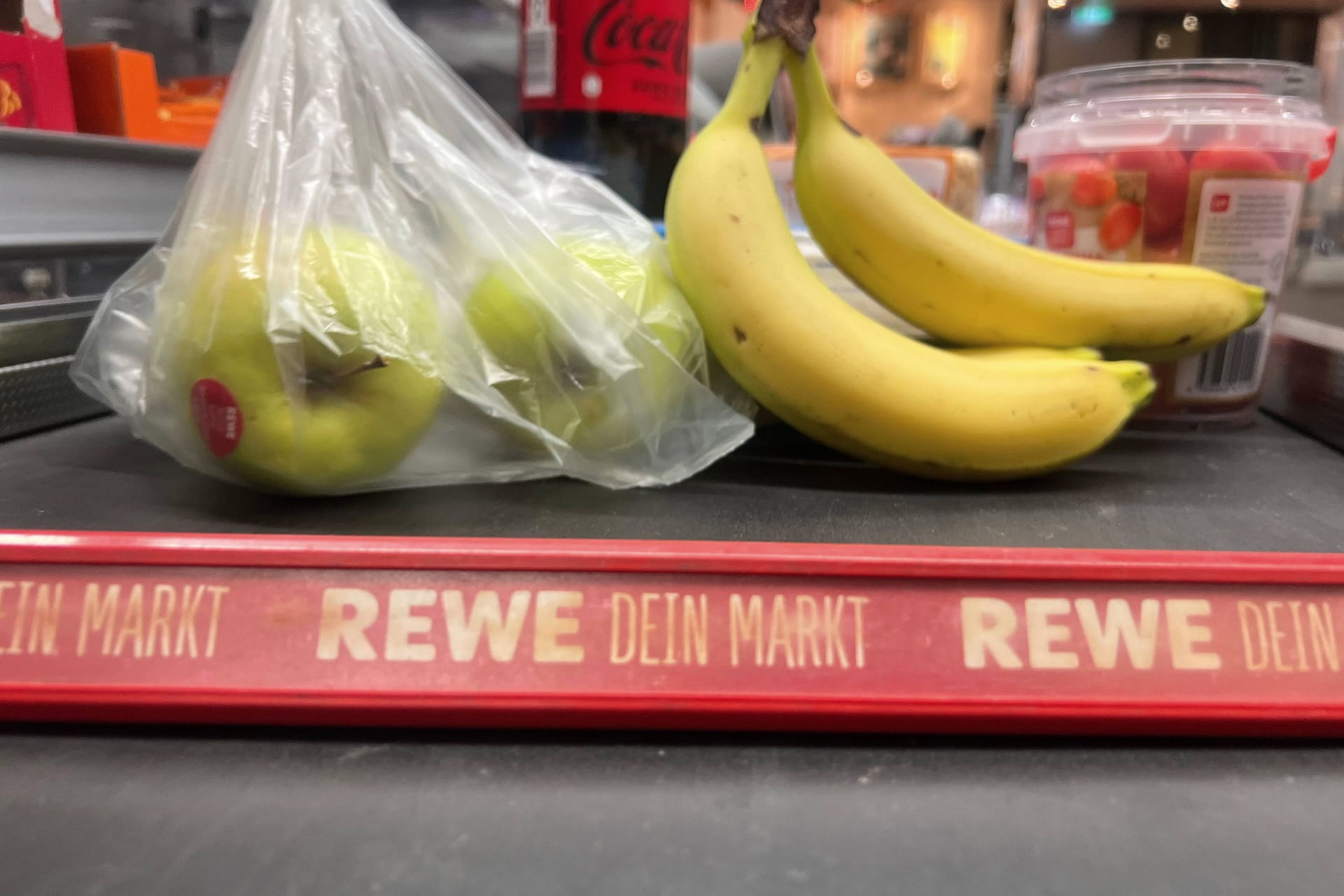 Ware auf dem Kassenband bei REWE: Zu erwarten ist, dass auch im kommenden Jahr die Preise weiter steigen.