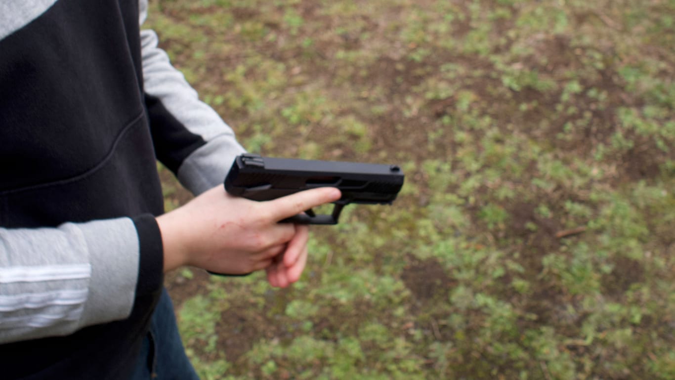Mann mit Waffe (Symbolbild): Die Täter in Dortmund sollen eine Pistole und ein Messer gehabt haben.
