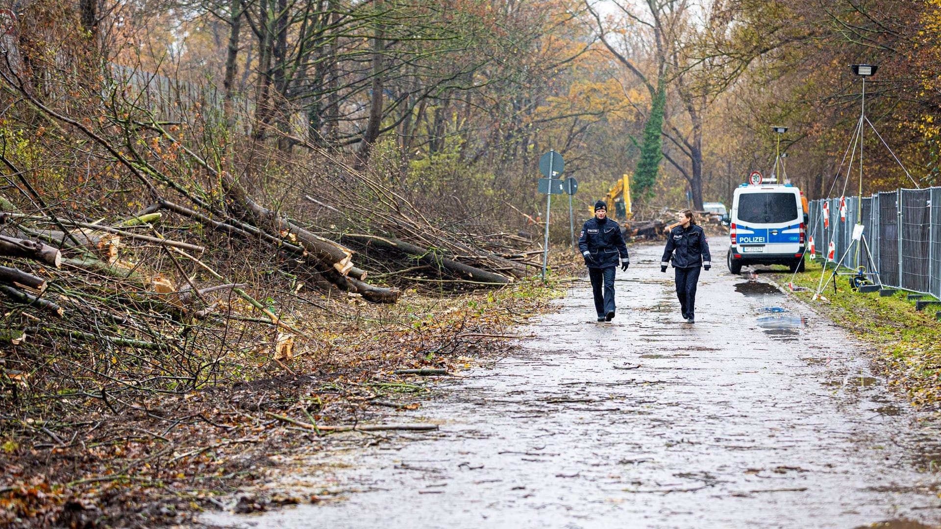 Einsatzkräfte der Polizei gehen an gerodeten Bäume neben dem gesperrten Südschnellweg (Bundesstraße 3) entlang.