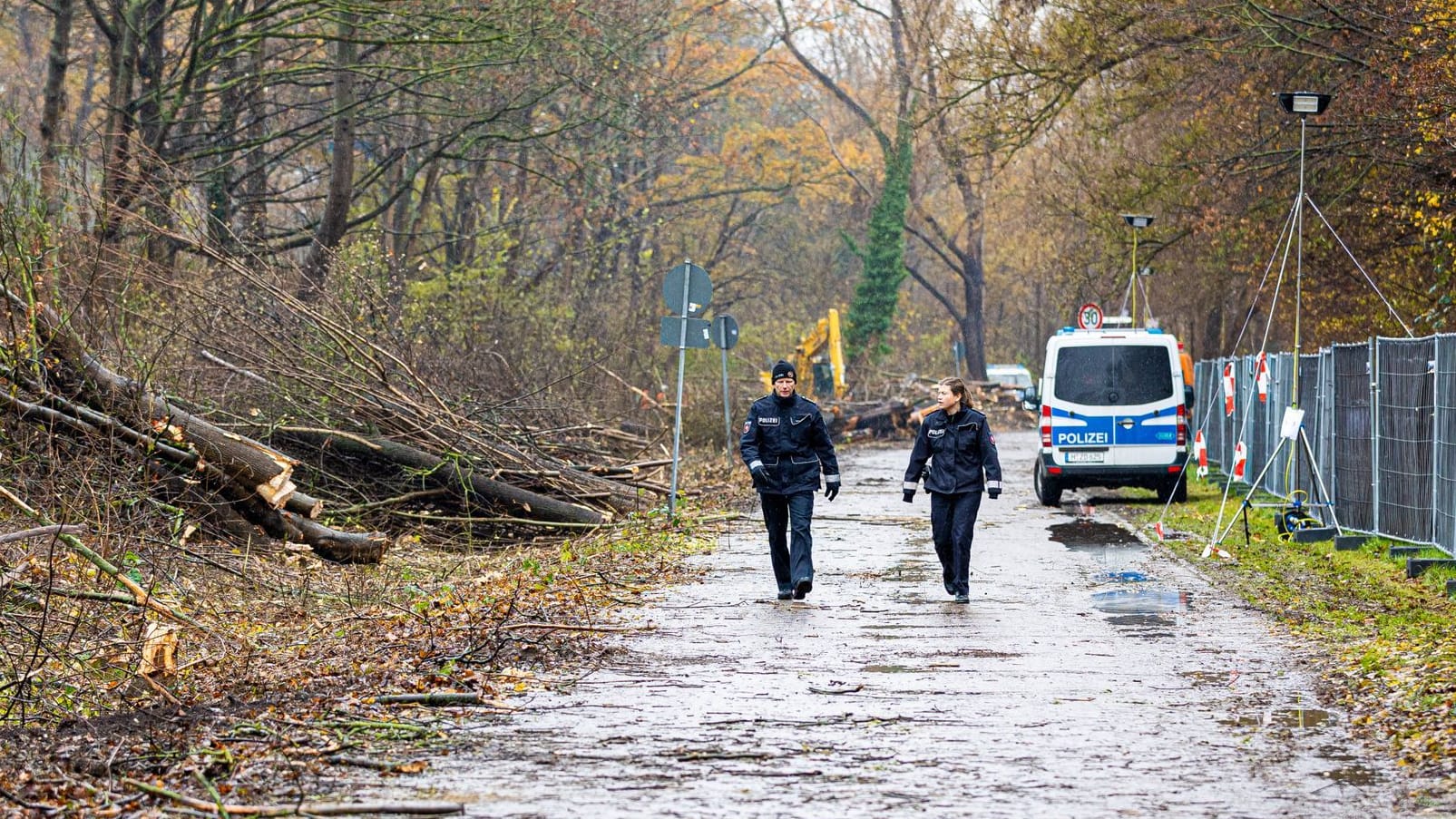 Einsatzkräfte der Polizei gehen an gerodeten Bäume neben dem gesperrten Südschnellweg (Bundesstraße 3) entlang.