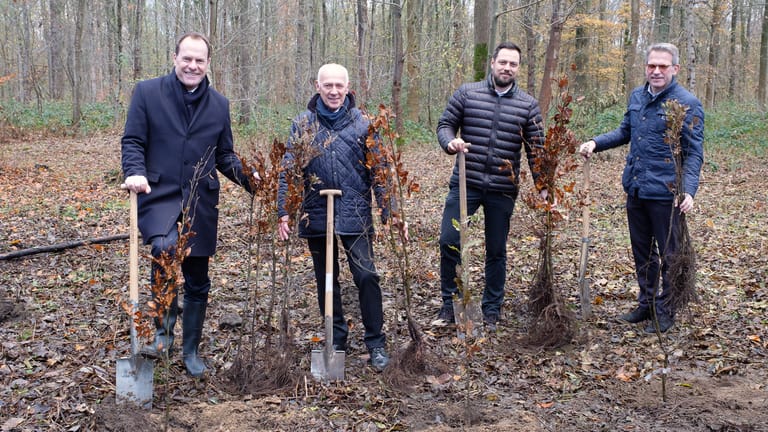 Oberbürgermeister Stefan Keller pflanzt zusammen mit den Baumspendern Setzlinge.