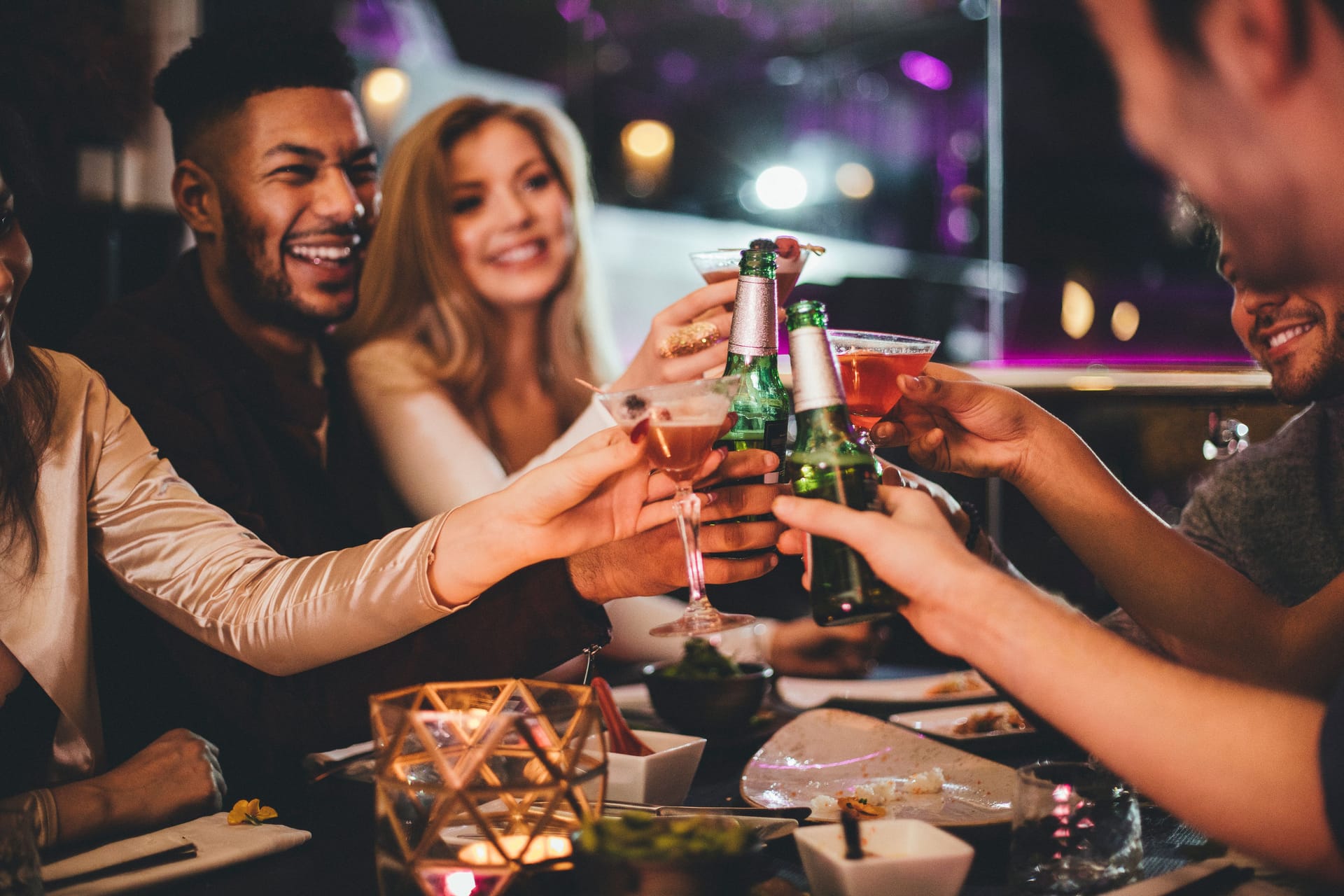 Eine Gruppe von Freunden stößt mit alkoholischen Getränken an.