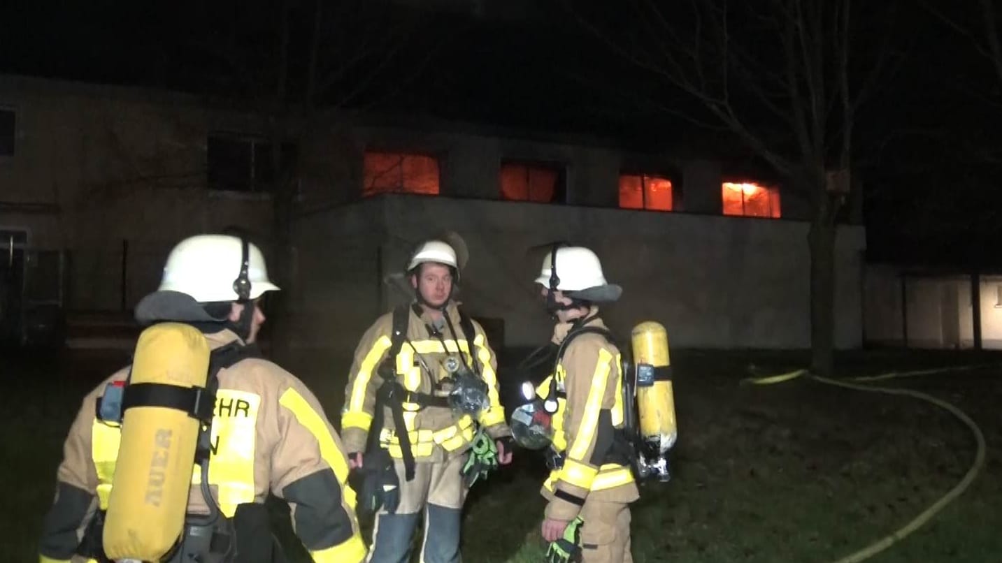 Einsatzkräfte vor der Turnhalle: In den Fenstern sind die Flammen zu sehen. Einsatzkräfte vor der Turnhalle: In den Fenstern sind die Flammen zu sehen.