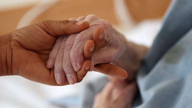 Pflegende Angehörige hält die Hand einer Frau (Symbolbild): Das Bürgerliche Gesetzbuch sieht einen Ausgleichsanspruch für Pflegende beim Erbe vor.