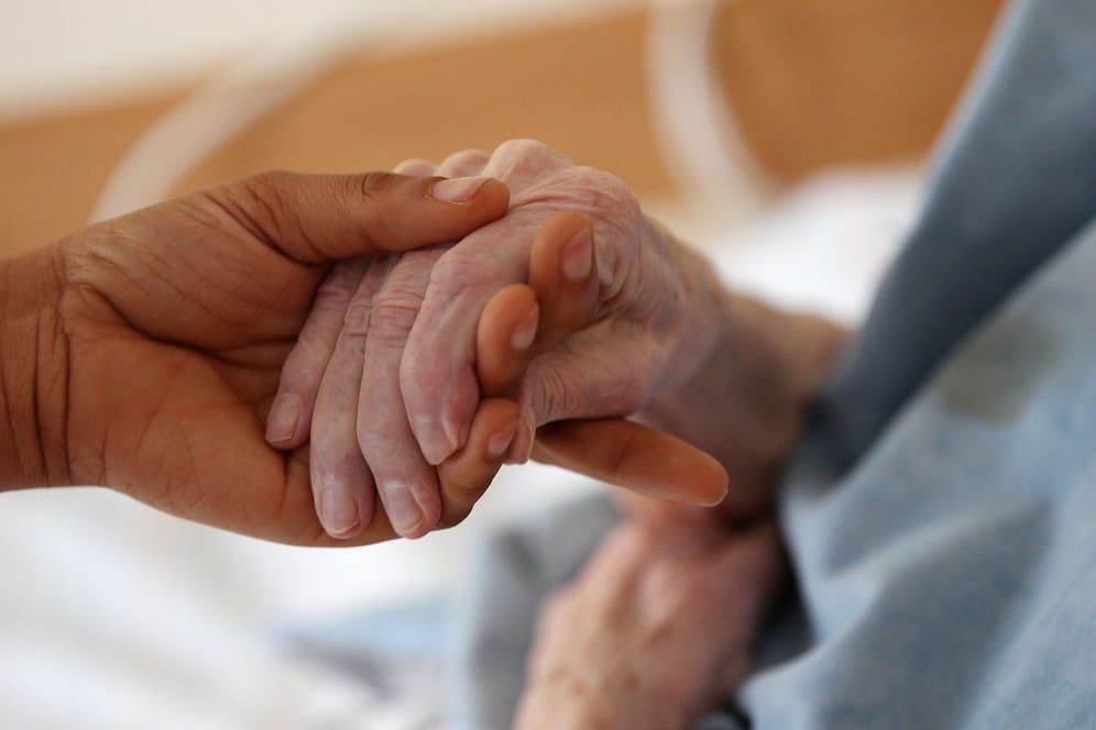 Pflegende Angehörige hält die Hand einer Frau (Symbolbild): Das Bürgerliche Gesetzbuch sieht einen Ausgleichsanspruch für Pflegende beim Erbe vor.