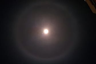 Ein Lichtschein zeichnet sich um den Mond herum ab: Die Wissenschaft spricht von einem "Halo", also "Heiligenschein".