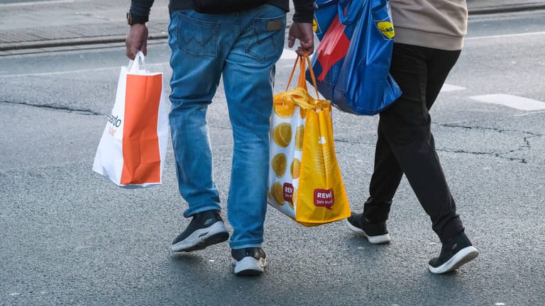 Menschen mit Einkaufstüten (Symbolbild): Die Inflation kostete Hartz-IV-Empfänger laut DGB Hunderte Euro Kaufkraft.