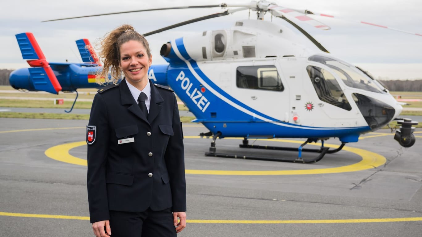Natalie Preiß, neue Leiterin der Polizeihubschrauberstaffel Niedersachsen, steht vor einem Polizeihubschrauber MD 902 Explorer am Flughafen Hannover.