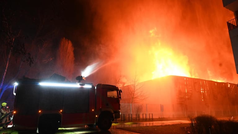 Ein Wasserwerfer bekämpft den Brand der Lagerhalle: Die Löscharbeiten dauerten in den Morgenstunden noch an.