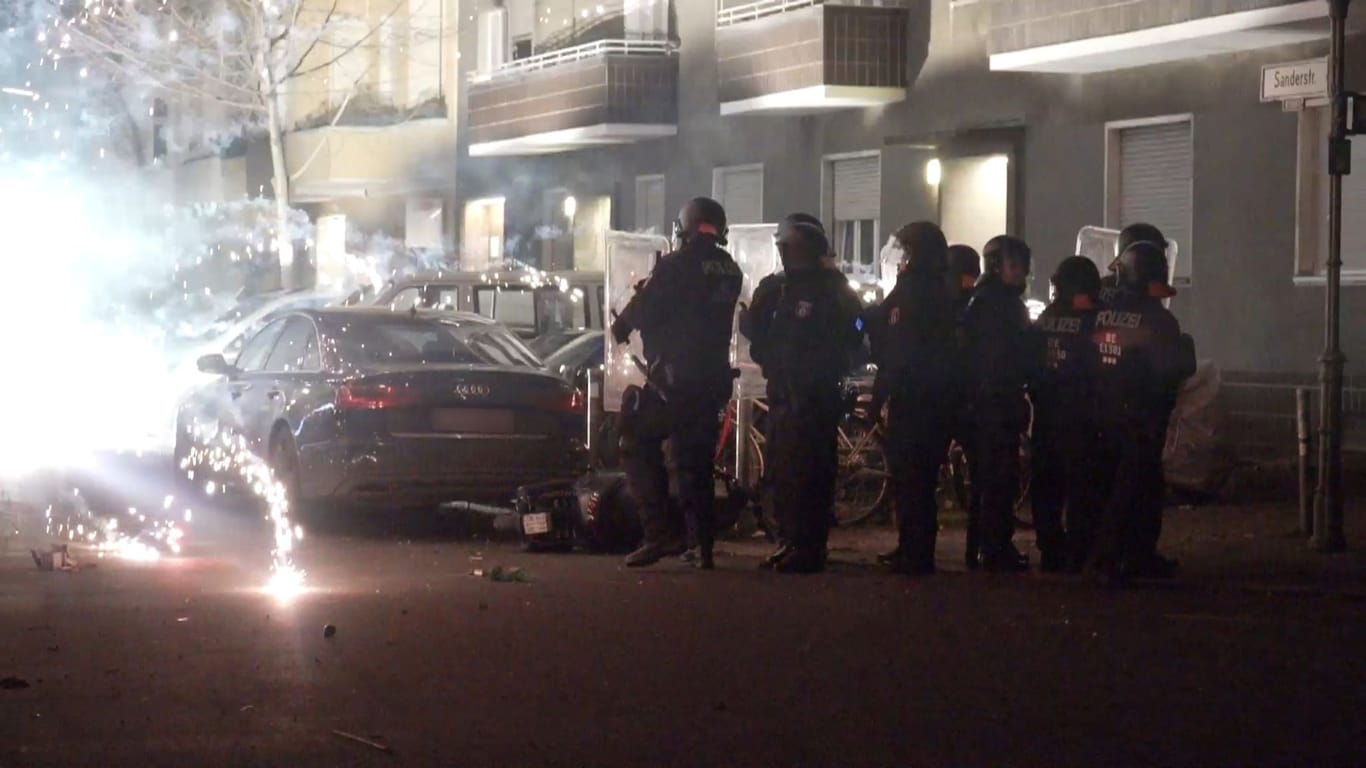 Polizeibeamte stehen hinter explodierendem Feuerwerk: In der Silvesternacht kam es auch in Berlin zu Angriffen auf Einsatzkräfte.