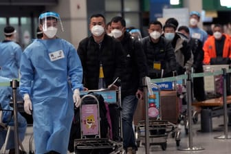 Reisende in China: Das Virus verbreitet sich über die Feiertage noch rasanter.