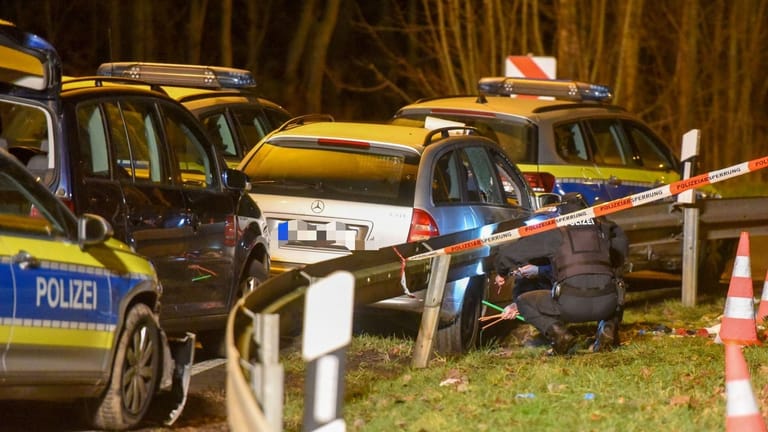 Einsatzkräfte arbeiten am Tatort: Die Scheiben des mutmaßlichen Fluchtwagens sind offenbar zu Bruch gegangen.