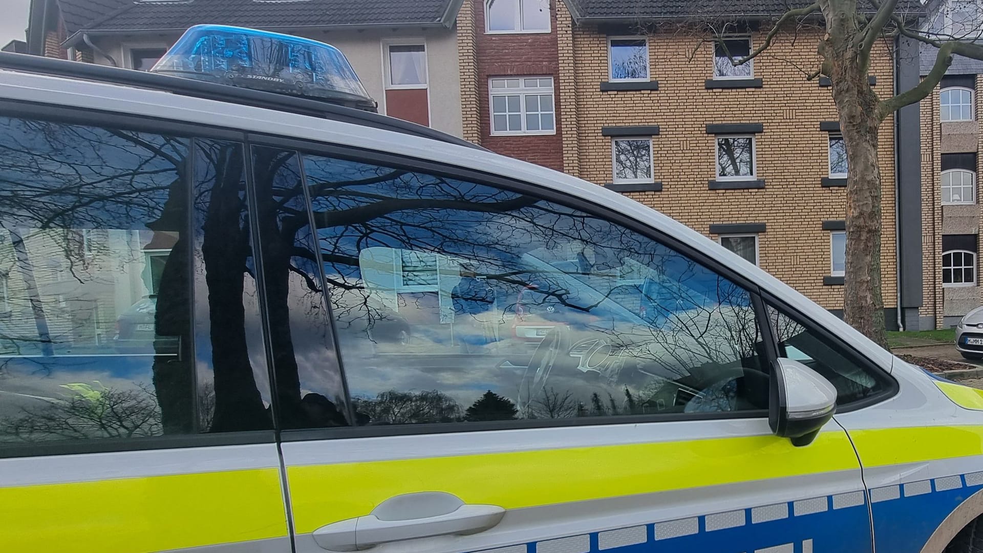 Ein Polizeiauto steht im Zuge von Ermittlungen vor einem Mehrfamilienhaus: In Barsinghausen wurde ein totes Kind gefunden.