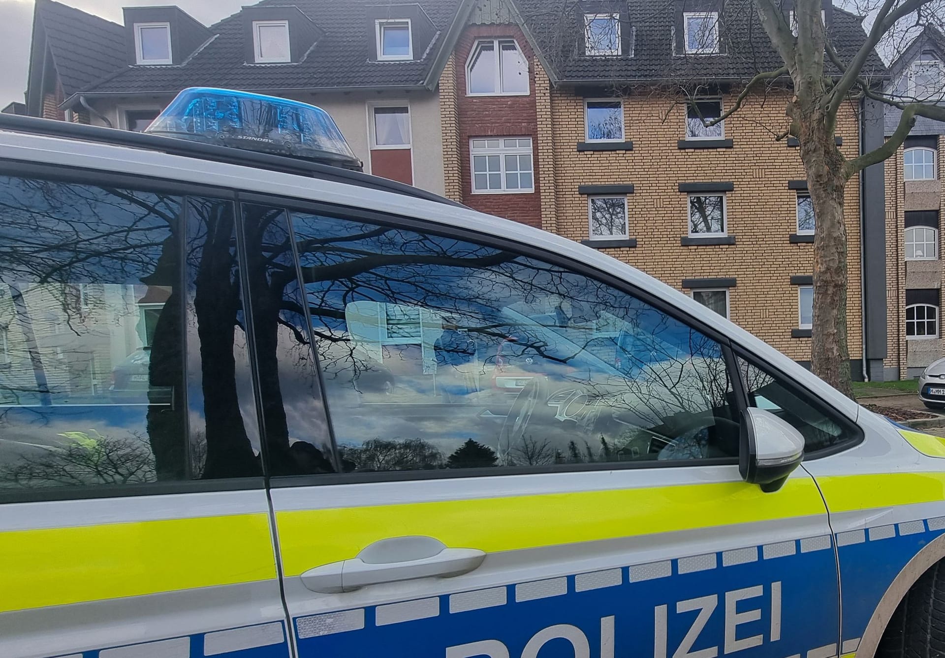 Ein Polizeiauto steht im Zuge von Ermittlungen vor einem Mehrfamilienhaus: In Barsinghausen wurde ein totes Kind gefunden.