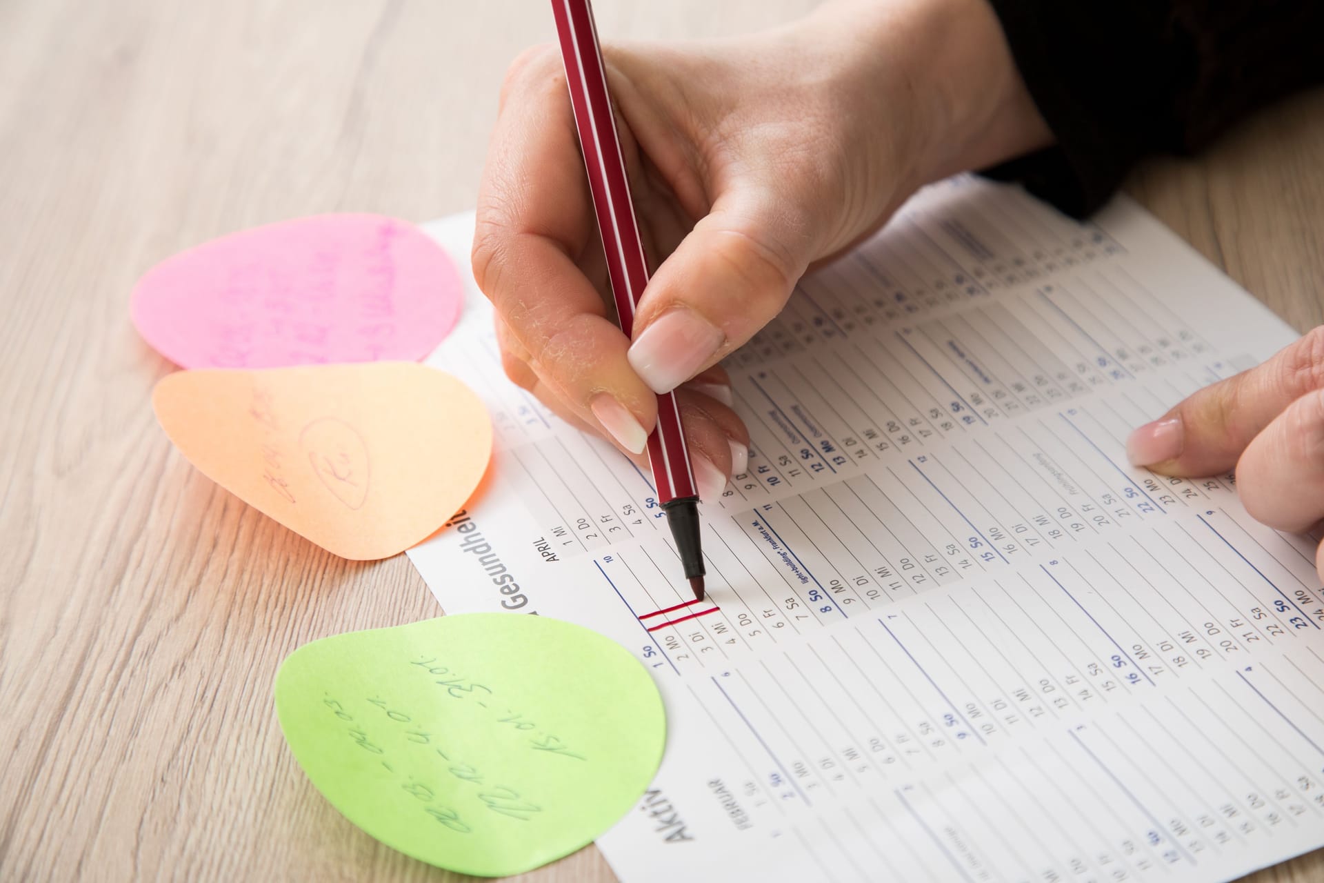 Eine Frau trägt freie Tage in einen Kalender ein (Symbolbild): Die Pflicht zur Arbeitszeiterfassung soll auch dafür sorgen, dass weniger unbezahlte Überstunden anfallen.