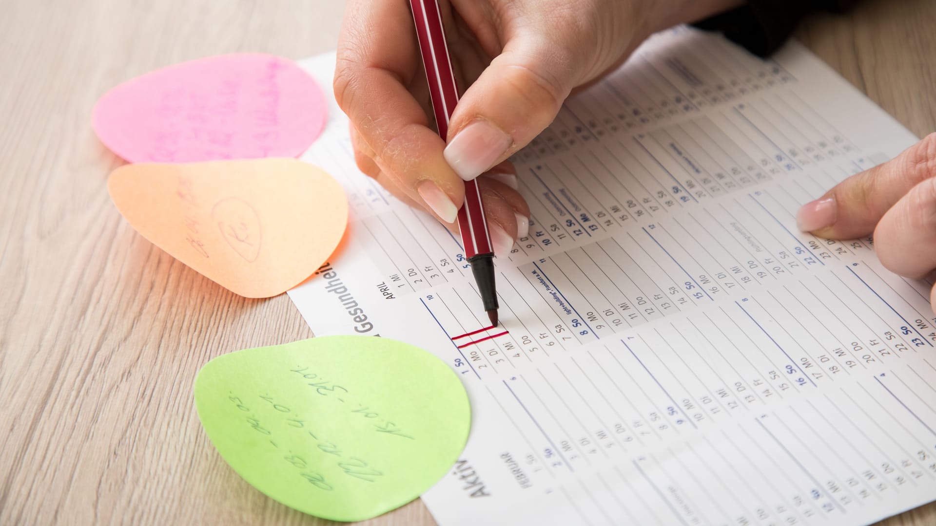 Eine Frau trägt freie Tage in einen Kalender ein (Symbolbild): Die Pflicht zur Arbeitszeiterfassung soll auch dafür sorgen, dass weniger unbezahlte Überstunden anfallen.