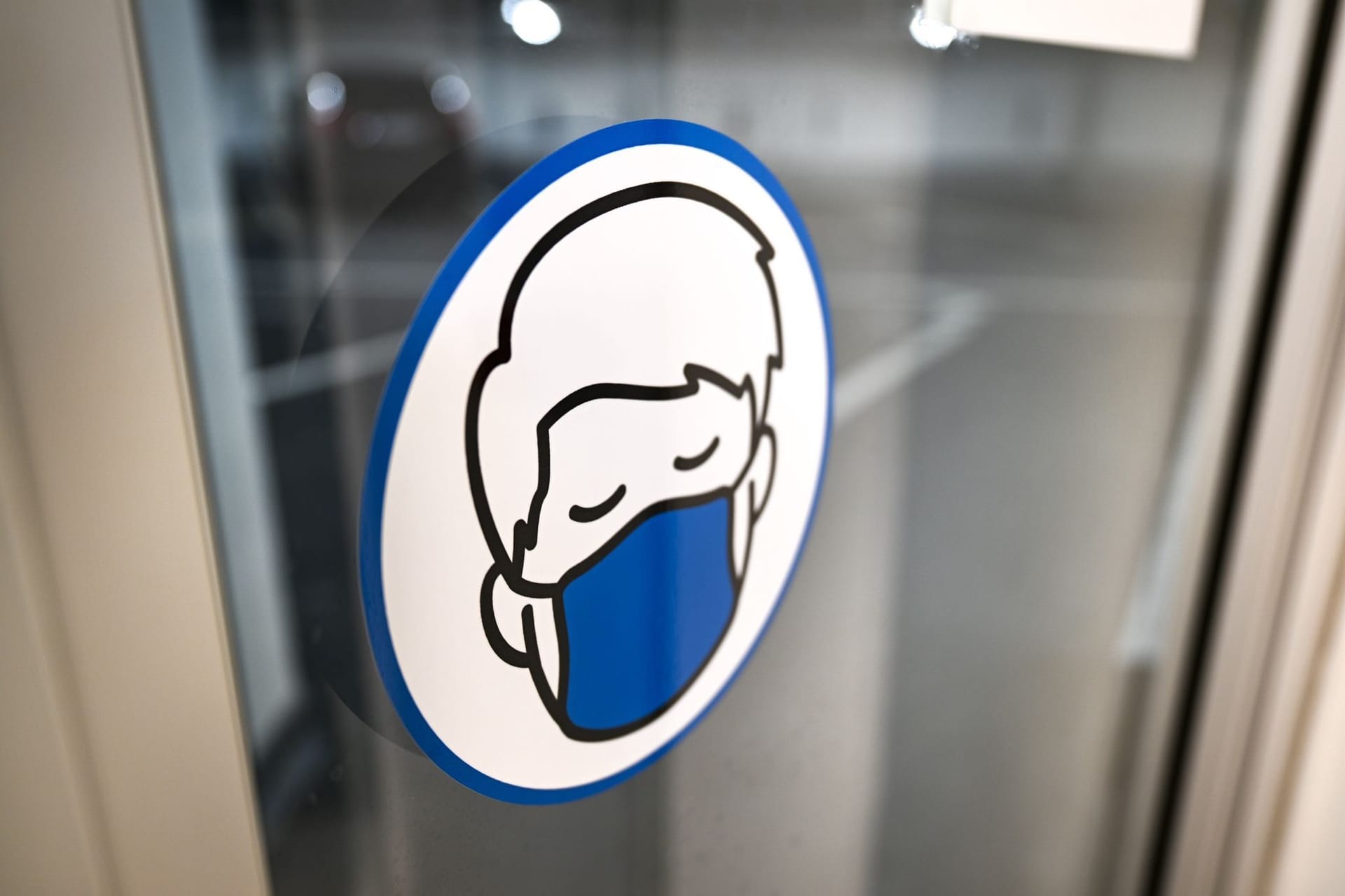 Ein Aufkleber an einer Glastür weist auf das Tragen einer Maske hin: Die Maskenpflicht im ÖPNV in Hamburg fällt.