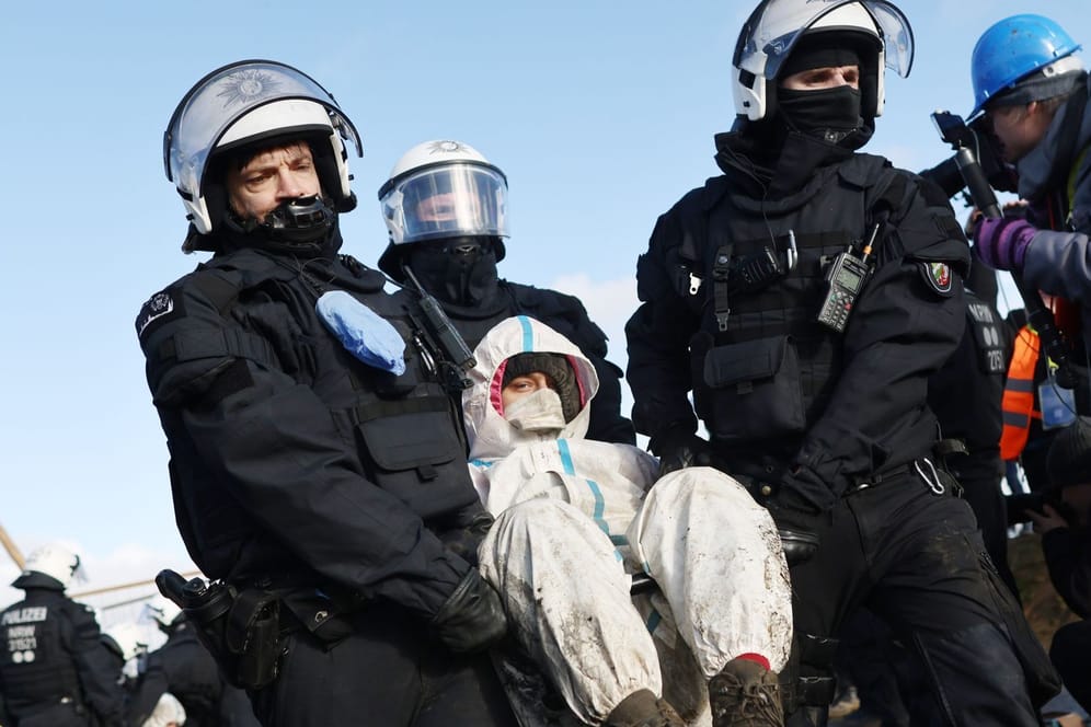 Polizisten tragen einen Klimaaktivisten weg: Schon bevor Beginn der Räumung wurde mit einer Eskalation in Lützerath gerechnet.