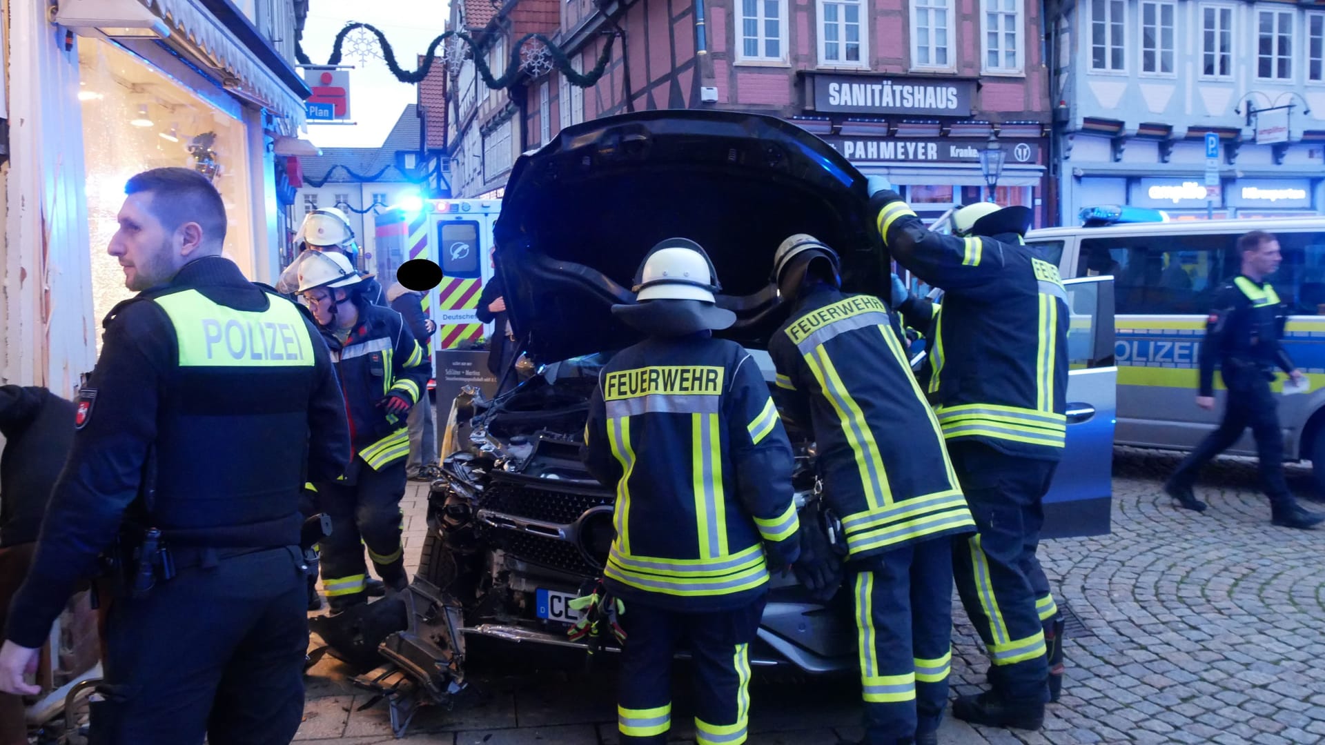 Feuerwehrkräfte versuchen das beschädigte Auto zu sichern.