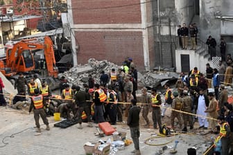 Sicherheitsleute und Aufräumarbeiter in Peshawar: Zunächst bekannte sich keine Gruppe zu dem Anschlag.
