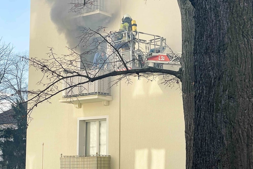 Frau steht auf Balkon von qualmender Wohnung: Als die Feuerwehrleute eintrafen, war eine sichere Rettung nur noch über den Balkon möglich.