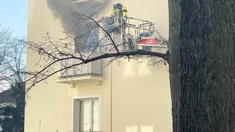 Frau steht auf Balkon von qualmender Wohnung: Als die Feuerwehrleute eintrafen, war eine sichere Rettung nur noch über den Balkon möglich.