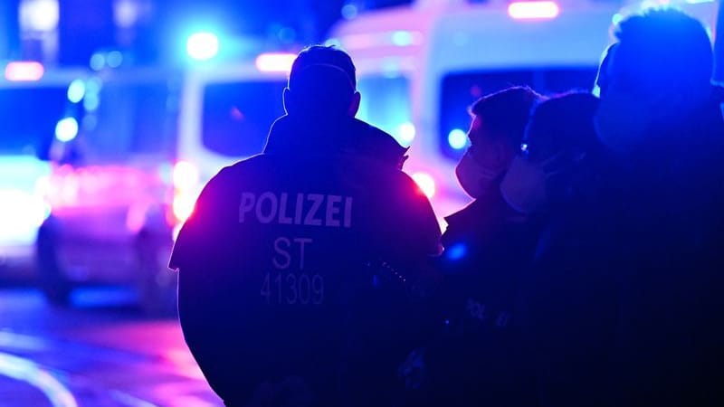 Polizisten stehen bei einem Einsatz auf der Straße (Symbolbild): Ein Mann wird gesucht. Polizisten stehen bei einem Einsatz auf der Straße (Symbolbild): Ein Mann wird gesucht.