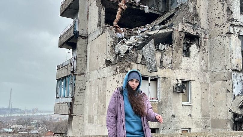 Sofia Makeeva posiert vor einem Haus in Mariupol.
