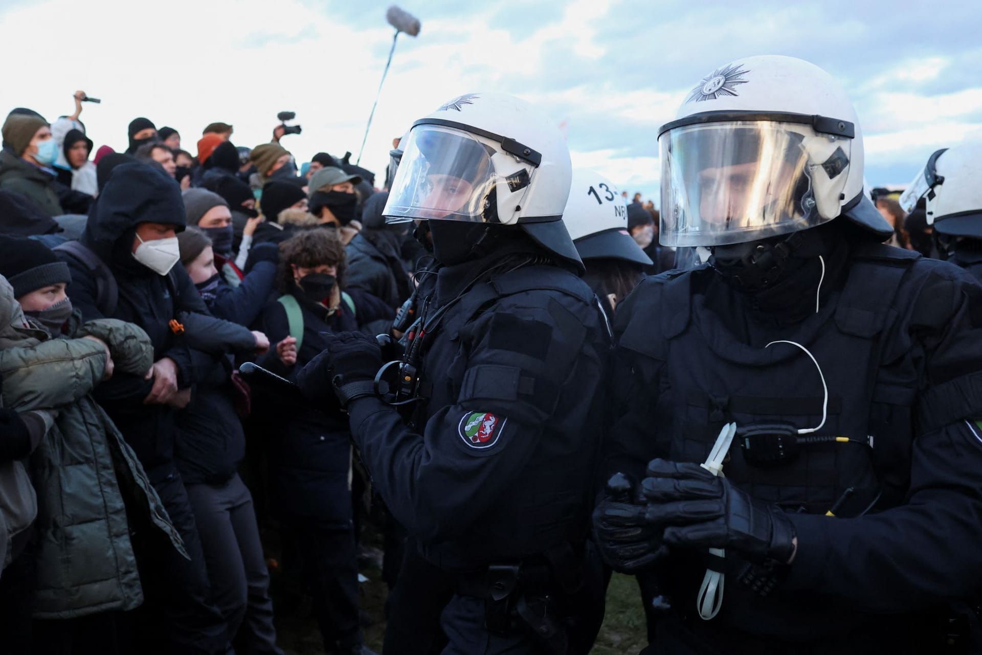 Polizisten halten Klimaaktivisten bei Lützerath in Schach.