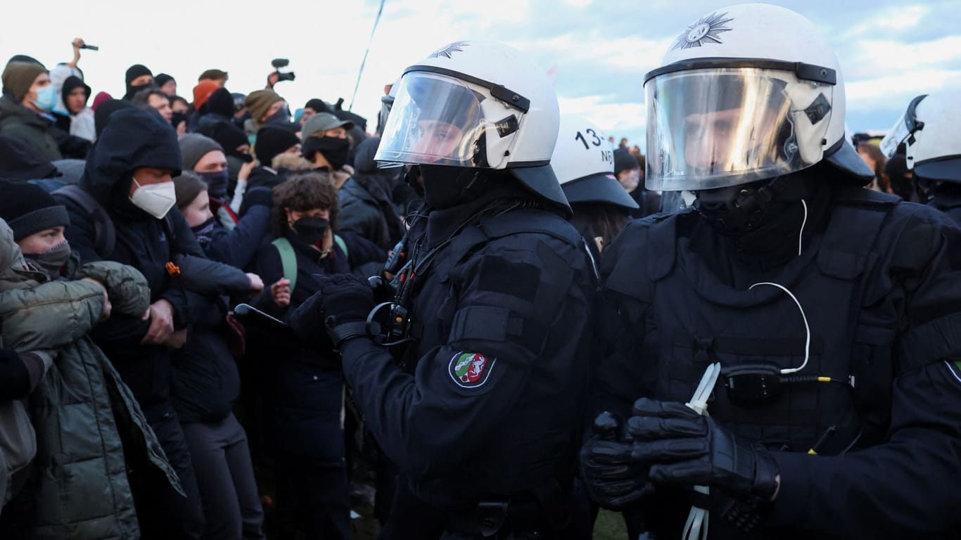 Polizisten halten Klimaaktivisten bei Lützerath in Schach.