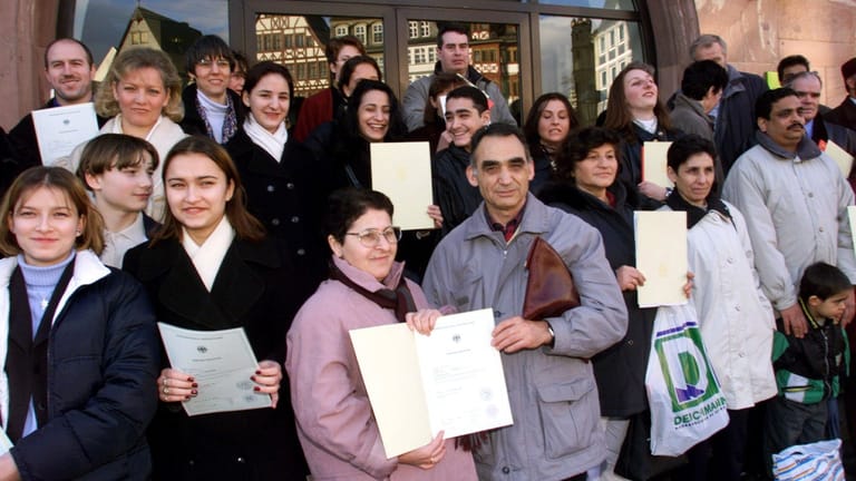 Menschen mit ihren Einbürgerungsurkunden (Archivbild): Die erste rot-grüne Koalition erleichterte die Einbürgerung.