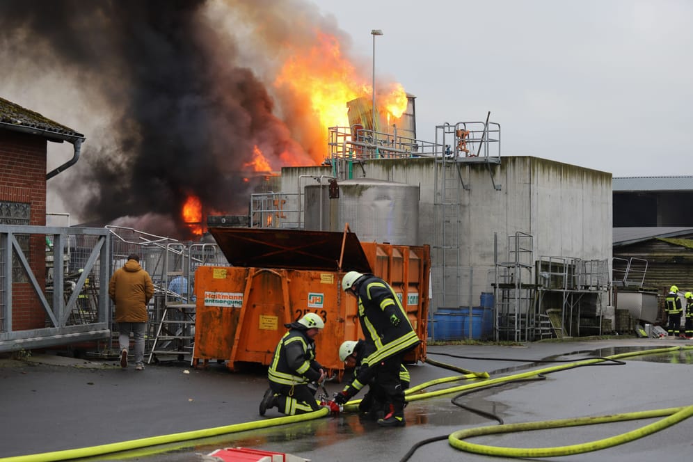 Einsatzkräfte der Feuerwehr vor dem brennenden Silo: Der Zugverkehr musste zeitweise eingestellt werden.