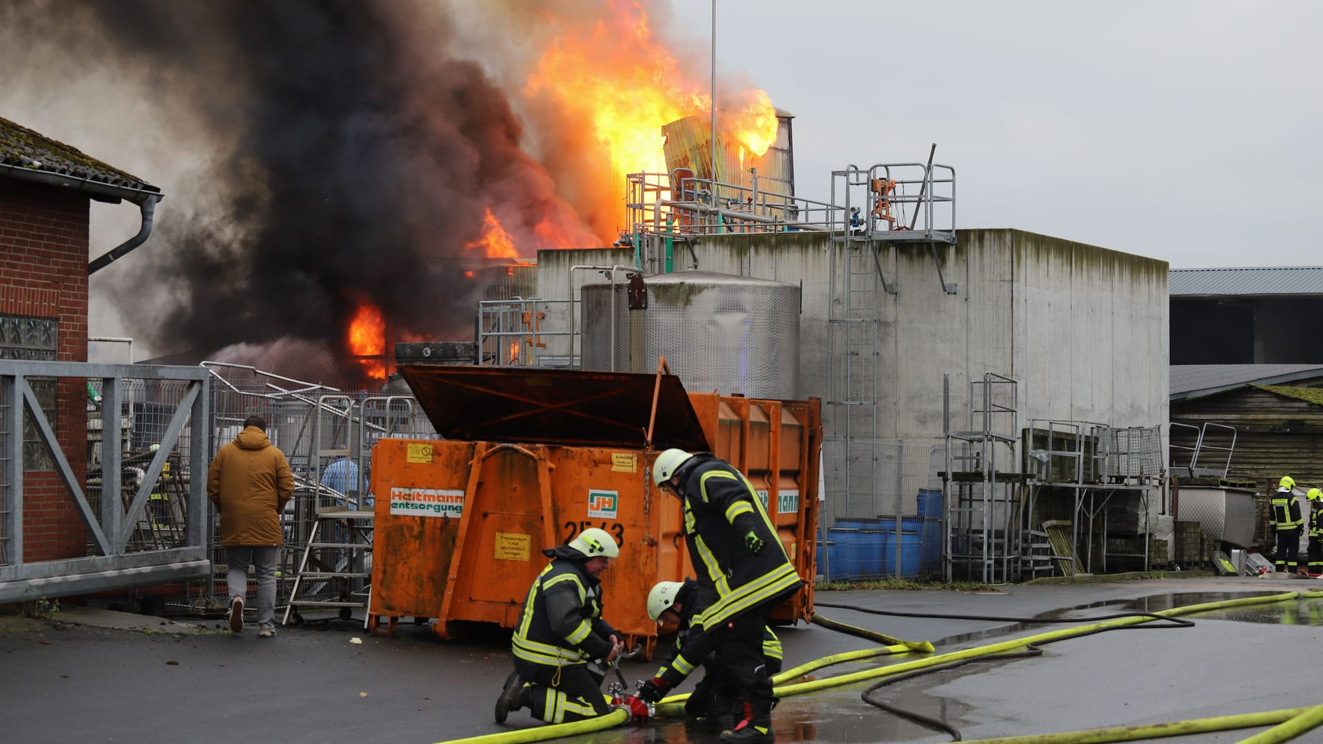 Einsatzkräfte der Feuerwehr vor dem brennenden Silo: Der Zugverkehr musste zeitweise eingestellt werden.