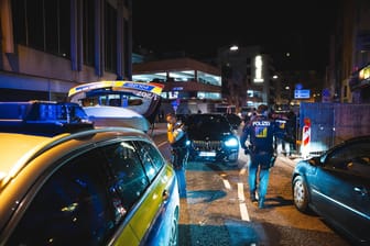 Der Streifenwagen nach dem Vorfall mitten in Stuttgart: Mehrere Polizeibeamte kümmern sich um den Schaden.