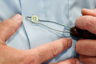 Kleiner Knopf, großes Gefriemel: Eine Knöpfhilfe erleichtert es Parkinson-Erkrankten, das Hemd zu schließen.